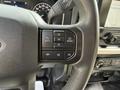 Close-up of the steering wheel controls of a 2021 Ford F-150 featuring buttons for back menu and audio settings