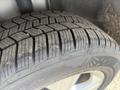 Close-up of a tire with a detailed tread pattern mounted on a rim designed for a 2014 Ford Escape