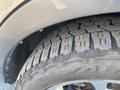 Close-up of a rugged tire on a 2016 Ford Escape showing deep treads and slight dirt accumulation on the surface