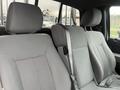 Interior view of a 2013 Ford F-150 showing two front seats in gray fabric with seatbelts and a divided armrest in the middle