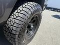 Close-up of a black wheel and tire of a 2010 Toyota Tacoma showcasing rugged treads and a sleek design