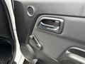 Interior door handle and crank of a 2011 Chevrolet Colorado with a textured panel and speaker grill