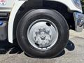 A close-up view of the wheel of a 2020 Hino 338 featuring a silver rim with multiple bolts and a black tire with visible tread patterns