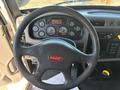 The interior of a 2015 Peterbilt 337 truck featuring a black steering wheel and a dashboard with various gauges and controls