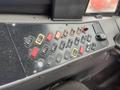 A control panel with various switches and buttons in different colors including red yellow and orange on a black surface