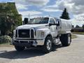 A 2016 Ford F-750 truck in white with a chrome grille and large tires parked on a road