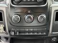 Control panel of a 2013 RAM 3500 featuring climate control knobs and various auxiliary switches