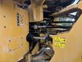 The image shows the hydraulic system and controls of a 2012 Caterpillar 980 heavy equipment loader with warning labels and machinery components visible