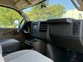 Interior view of a 2024 Chevrolet Express showing the dashboard and driver's seat with controls and storage compartments
