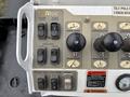 Control panel of an Altec aerial lift truck featuring various buttons and levers for operations like boom raise and lower, auger release, and digger functions