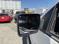 A side mirror of a 2014 Ford F-150 showing a reflection of nearby vehicles in a parking lot
