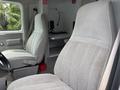 Interior of a 1994 GMC Vandura 3500 featuring two gray bucket seats with fabric upholstery and a dashboard area visible in the background
