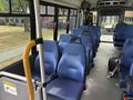 Interior of a 2020 Chevrolet Express bus featuring blue fabric seats and a handrail near the entrance with an empty cabin space