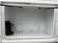 An open compartment of a 2020 International MV607 showing a chain and a bracket mounted on the left side with an empty space for storage on the right