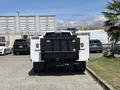 A 2021 RAM 5500 truck with a black flatbed and white body is parked facing forward in a lot