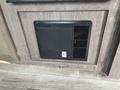 A black heating unit with a vent is installed in a wooden panel near the floor of a 2021 Jayco Jay Flight camper