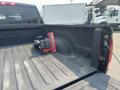 A 2015 RAM 1500 truck bed with a red and black tool or equipment resting on the floor