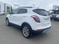 A white 2018 Buick Encore is shown from a rear angle with a sporty design and modern features, including a sleek shape and alloy wheels