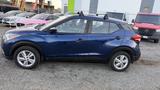 A blue 2019 Nissan Kicks parked with a side view showing its sleek design compact body and roof rails