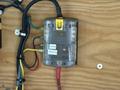 A fuse box with multiple colored wires attached including yellow red blue and green wires all connected to a transparent plastic housing