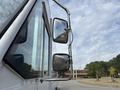 A 2018 Ford Econoline with prominent side mirrors reflecting light