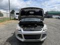 A 2015 Ford Escape with its hood open displaying the engine compartment