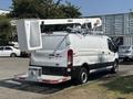 A white 2019 Ford Transit 350 van with a mounted aerial lift on the roof and a utility bucket attached at the top