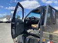 A black 1996 GMC Top Kick with an open door showing the driver's seat and dashboard inside the cab