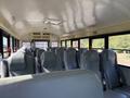 Interior view of a 2013 International CE300 school bus with rows of gray leather seats and no passengers