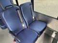 Two blue upholstered seats with seatbelts in a vehicle interior