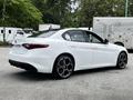A white 2023 Alfa Romeo Giulia with distinctive rear design and sporty alloy wheels showcasing a sleek aesthetic and modern features