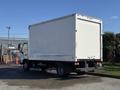 A 2014 Hino 195 box truck loaded with a plain white cargo area and visible rear lights parked on a paved surface