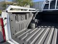 A 2021 Ford F-250 SD truck bed showing a textured surface with a wheel well and various attachment points