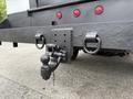 A close-up of a 2020 Ford F-550's towing hitch attached to a black metal frame with chains and multiple holes for securing connections