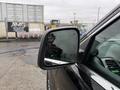 A close-up of a side mirror on a 2019 Jeep Grand Cherokee with raindrops on the glass