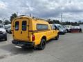 A yellow 2013 Ford F-250 SD with a truck cap and black wheels parked at an angle in a lot