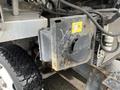 Close-up of a rusty component attached to the side of a 2012 Workhorse W62 with visible wiring and an electrical housing attached to the assembly