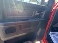 Interior door panel of a 2015 RAM 2500 featuring a black armrest and window controls with a textured surface