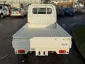 A white 2008 Suzuki Carry truck with an open bed and a cab at the front viewed from the rear