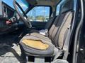 A worn driver's seat of a 1996 GMC Top Kick showing frayed fabric and exposed foam padding with a steering wheel and dashboard visible in the foreground