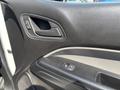 A black and gray interior door panel of a 2017 Chevrolet Colorado featuring a handle power window control and textured surface