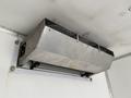 A stainless steel refrigeration unit mounted on the interior wall of a freight truck