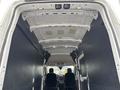 Interior view of a 2020 Ford Transit 250 cargo van with two black seats visible and a spacious empty cargo area featuring a white ceiling and black walls