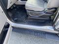A 2015 Ford F-150 interior showing the driver's side seat and floor area with a rubber mat and a step plate with the Ford logo