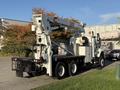 A 2011 International 7500 truck equipped with a crane and utility bed is parked on a surface with visible tires and rear lights