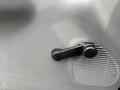 A black handle on the dashboard of a 2004 Ford F-350 SD used for adjusting the air vent