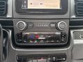 Dashboard controls of a 2023 RAM Promaster 3500 featuring knobs for volume and mute along with climate control buttons and a screen displaying settings