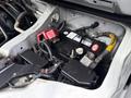 A battery and various components inside the engine compartment of a 2009 Toyota Hiace