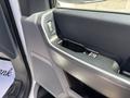 A close-up view of the inner door panel of a 2021 Ford F-150 featuring a power window switch and a storage compartment