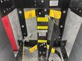 A 2006 E-One Typhoon fire truck seat with safety warning labels and a metal bracket for securing equipment